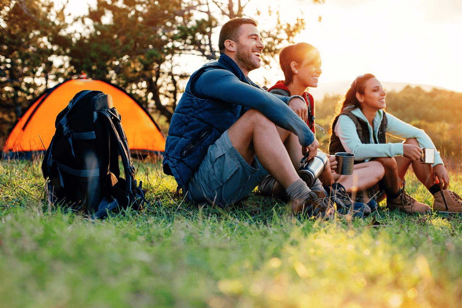 טיול קמפינג באתר קמפינג. ברקע אוהל איכותי ושקיעה פסטורלית - לייפסטייל